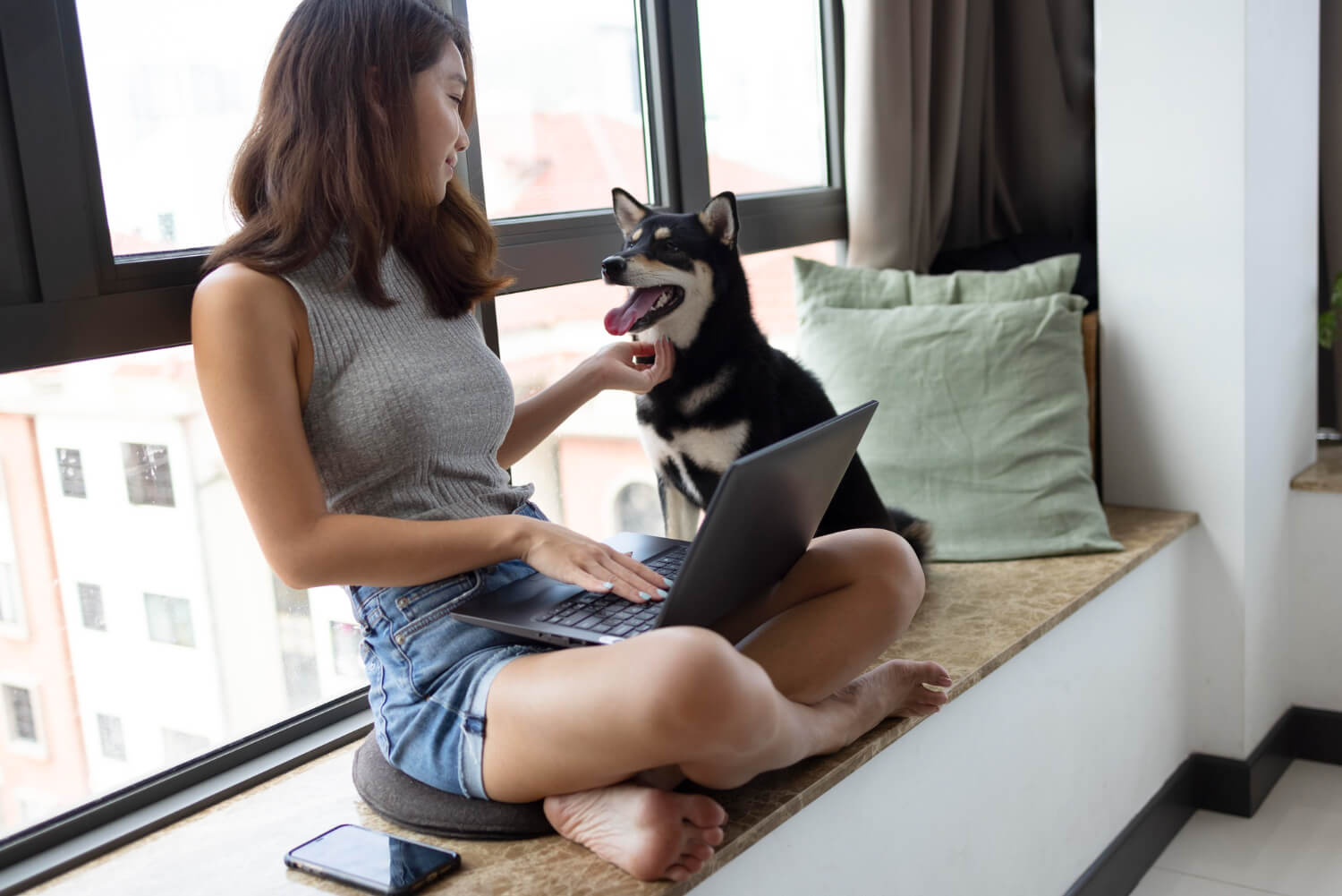 Foto de mulher brincando com cão dentro de um apartamento